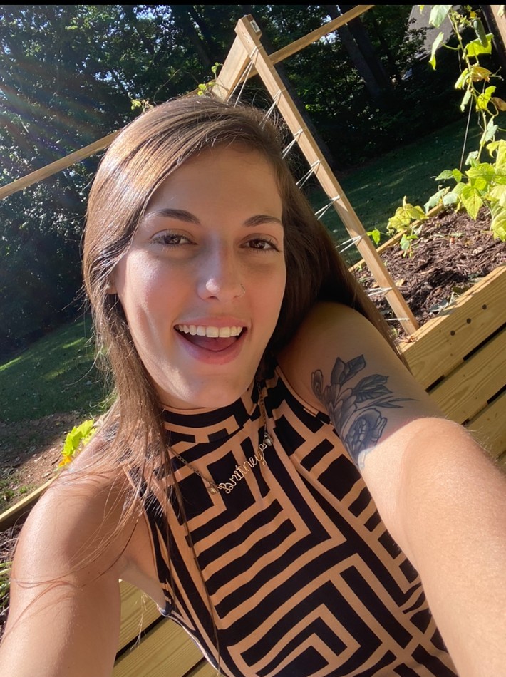 Britney, owner and director of Sunny Day Kids Camp, smiling outdoors in her garden
